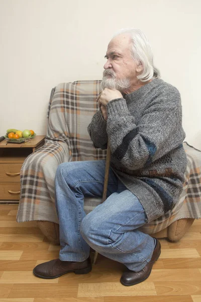 一个悲伤的老人在孤儿院里独自坐在椅子上 在过去的岁月里反映出 — 图库照片