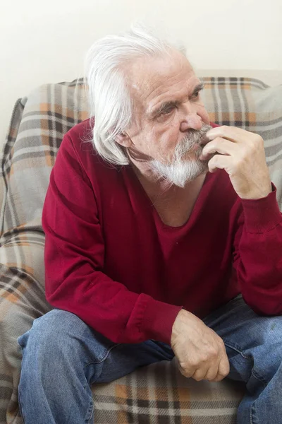 一个英俊的有病老头 留着胡子 长着白头发的胡子在养老院里独自坐在扶手椅上 反映了过去的岁月 — 图库照片
