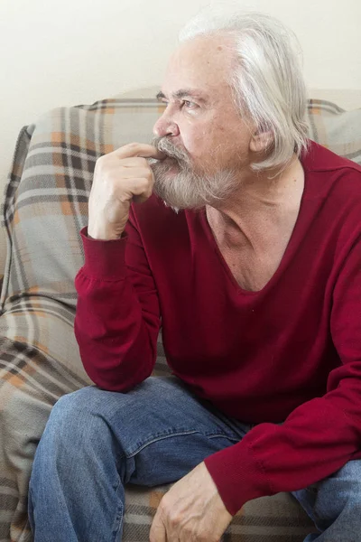一个英俊的有病老头 留着胡子 长着白头发的胡子在养老院里独自坐在扶手椅上 反映了过去的岁月 — 图库照片