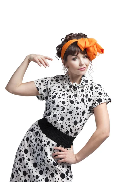 一个年轻的女孩穿着用波尔卡圆点布做的夏装 头发上有一个蝴蝶结 手里拿着篮子跳舞 在演播室里摆出白色背景的姿势 — 图库照片