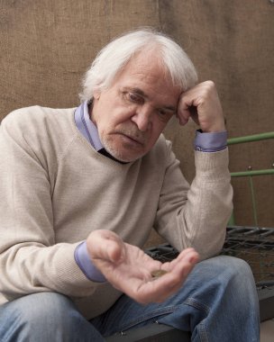 Hangi bir yatak yerine kafes tel bir demir yatak, üzerinde oturan zavallı yalnız erkek emekli