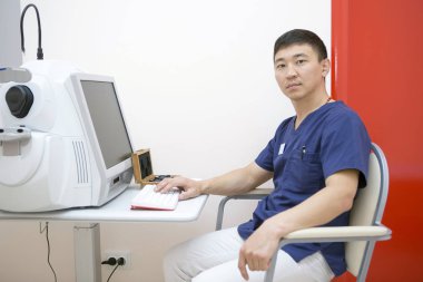 Aygıtla birlikte çalışma onun işyerinde Asya erkek göz doktoru olduğunu