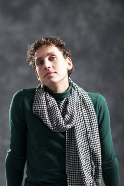 Kıvırcık saçları ve onun boynuna bir eşarp ile büyüleyici genç adam