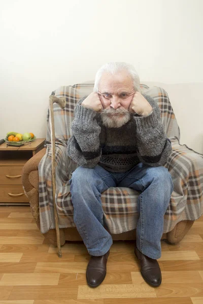 Старик в кресле дома — стоковое фото