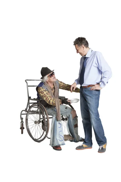 Beggar asking for alms while sitting in a wheelchair — Stock Photo, Image