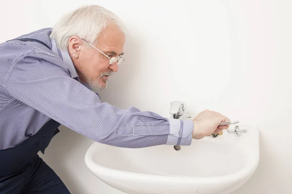 Master repairs washbasin sink — Stock Photo, Image