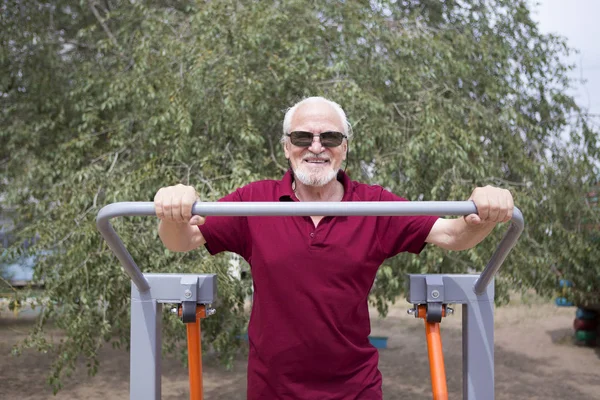 Hombre mayor entrena en equipos deportivos al aire libre —  Fotos de Stock