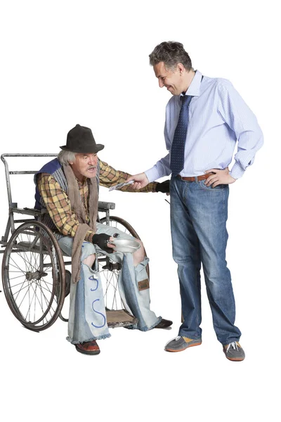 Beggar asking for alms while sitting in a wheelchair — Stock Photo, Image