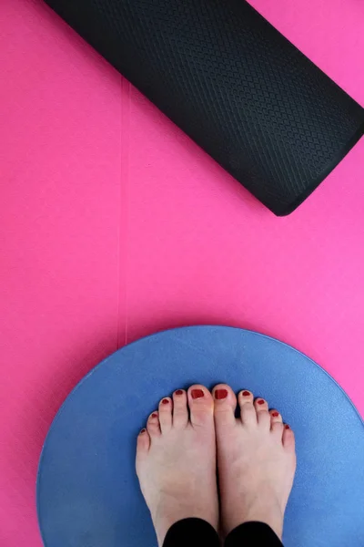 Exercise with a balance board, foam roller and pink yoga mat