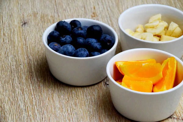 Healthy Fresh Blueberries Banana Orange Slices White Bowls Wooden Table — Stock Photo, Image