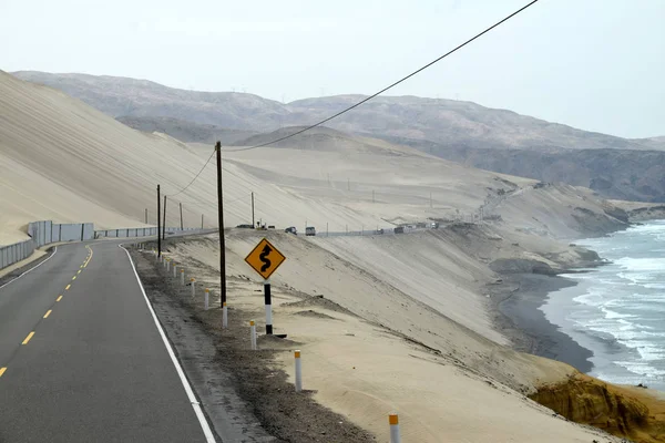 沿着海岸线蜿蜒前行的道路 在很远的地方 远处是卡车 泛美公路的道路部分 在秘鲁拍摄的照片 — 图库照片