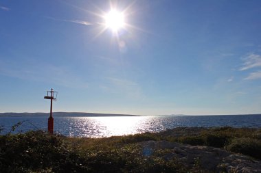 Küçük bir deniz feneri ile Povljana sahilde kıyı şeridi. Gökyüzünde güneş yüksek. Povljana beach Island Pag, Hırvatistan.