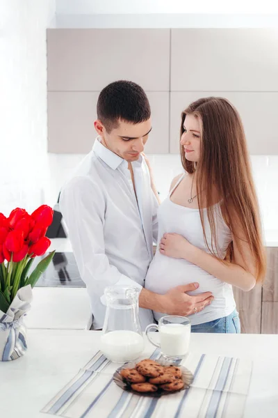 キッチンで夫との幸せな妊娠中の女性の肖像画 — ストック写真