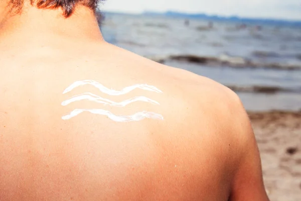 Lotion man with sunscreen sea waves on the sea background