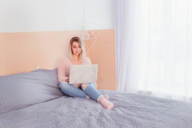 Şoförünün yatakta oturup bir dizüstü bilgisayar üzerinde çalışan mutlu rahat güzel kadın