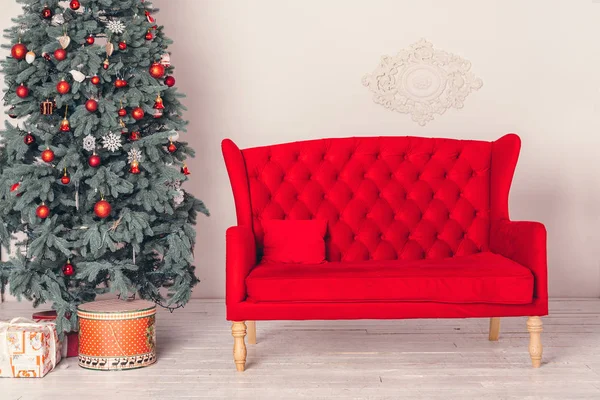 Διακοσμημένο Χριστουγεννιάτικο Δέντρο Και Ένα Κόκκινο Καναπέ Στο Δωμάτιο — Φωτογραφία Αρχείου