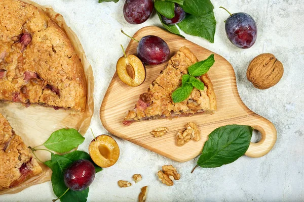 Delicious sweet pie with plums and walnuts. Closed pie. Sweet autumn dessert