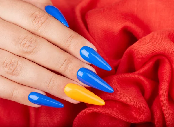 Hand Met Kunstmatige Gemanicuurde Nagels Gekleurd Met Blauwe Oranje Nagellak — Stockfoto