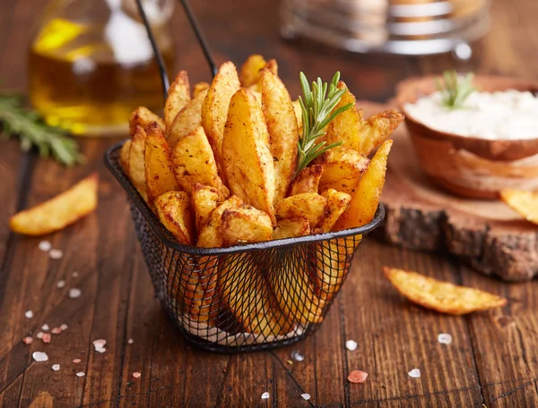 Biberiyeyle pişirilmiş patates dilimleri. Sosla servis edilen lezzetli atıştırmalıklar. Fast food.