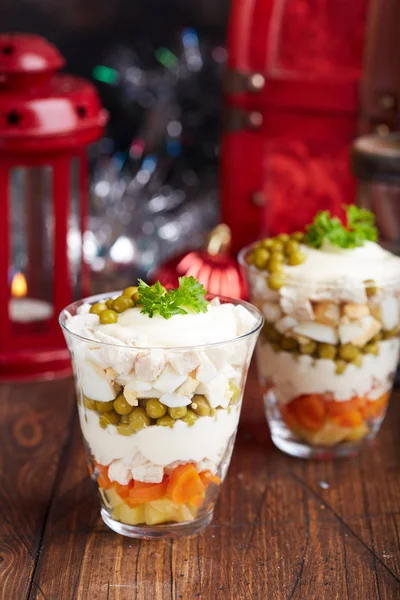 Layered Olivier salad with boiled vegetables in portion jar. Traditional Russian cuisine.
