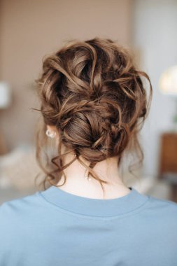 Kahverengi saçlı bir kadının kafasında kompleks saç stili, yakın plan. İyi akşamlar. her gün saç stili
