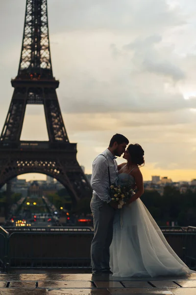 エッフェル塔を背景にした花嫁と新郎のシルエット キスの前の瞬間 パリで結婚式 ピンクオレンジの空 エッフェル塔のシルエット — ストック写真