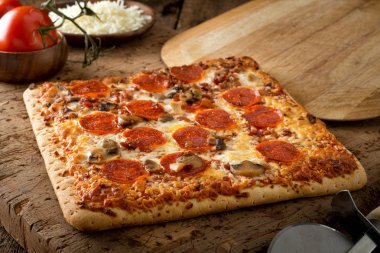 Lezzetli kare kabuk gözleme pizza sucuk, pastırma ve rustik ahşap masa üstüne mantar ile.