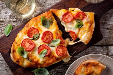 Güzel kırsal ev yapımı pizza margherita taze mozzarella peyniri, roma domates ve fesleğen ile.