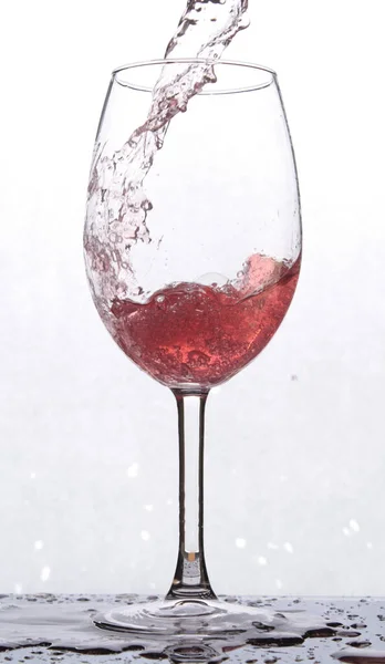 Ein Glas Mit Roter Flüssigkeit Das Auf Einer Spiegeloberfläche Steht — Stockfoto