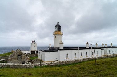 Dunnet kafa, en Kuzey noktası deniz feneri ile İngiltere'de anakara arka planda