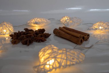  Yıldız anason, tarçın ve beyaz zemin üzerine beyaz kalpler.