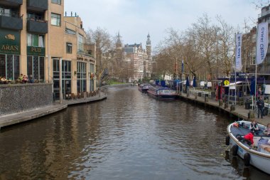 Amsterdam/Hollanda, 06 Nisan 2019: Amsterdam 'da çok sayıda kanal boyunca eski sokaklar. Nehir taşımacılığı ve bisikletler