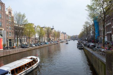 Amsterdam/Hollanda, 06 Nisan 2019: Amsterdam 'da çok sayıda kanal boyunca eski sokaklar. Nehir taşımacılığı ve bisikletler