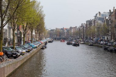 Amsterdam/Hollanda, 06 Nisan 2019: Amsterdam 'da çok sayıda kanal boyunca eski sokaklar. Nehir taşımacılığı ve bisikletler