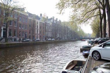 Amsterdam/Hollanda, 06 Nisan 2019: Amsterdam sokaklarında yürüyün. Kanallar, laleler, bisikletler, tekneler.