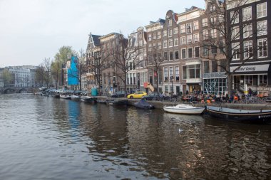 Amsterdam/Hollanda, 06 Nisan 2019: Amsterdam sokaklarında yürüyün. Kanallar, laleler, bisikletler, tekneler.