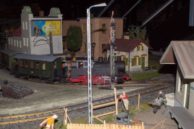 Demiryolu, trenler, raylar ve tren istasyonu düzeni, demiryolu işçilerinin yaşam minyatür sahneleri gece sahnesi.