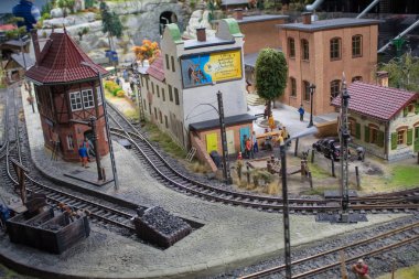 Demiryolu, tren, raylar ve tren istasyonunun düzeni veya minyatürü, demiryolu işçilerinin çalışmalarının minyatür sahneleri.