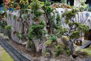 Demiryolu, tren, raylar ve tren istasyonunun düzeni veya minyatürü, demiryolu işçilerinin çalışmalarının minyatür sahneleri.