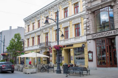 Lodz, Polonya - 09 Temmuz 2019: Yağmurlu bir yaz gününde tarihi evleri ile Polonya'nın Lodz şehrinin güzel tarihi merkezi sokak.