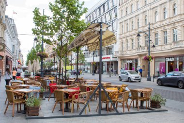 Lodz, Polonya - 09 Temmuz 2019: Yağmurlu bir yaz gününde tarihi evleri ile Polonya'nın Lodz şehrinin güzel tarihi merkezi sokak.