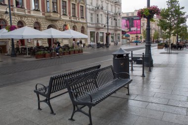 Lodz, Polonya - 09 Temmuz 2019: Yağmurlu bir yaz gününde tarihi evleri ile Polonya'nın Lodz şehrinin güzel tarihi merkezi sokak.