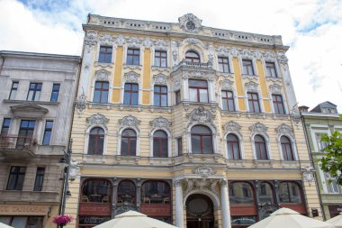 Lodz, Polonya - 09 Temmuz 2019: Yaz mevsiminin doruğunda Polonya'nın Lodz şehrinin merkezi tarihi caddesinde turistler için masa ve masalarla rahat kafeler.