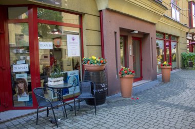Yaz güneşli gününde şehir Lodz ağaçlarda renkli mobilyalar, çiçek açan çiçekler ve parlak şapkalar ile rahat renkli avlu.