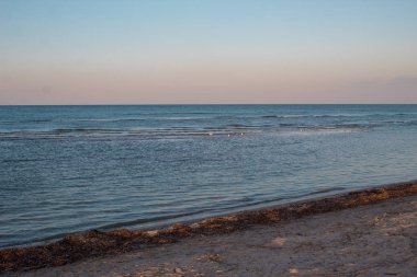 Güzel deniz manzarası - denizde gün batımı ve parlak pembe-mavi gökyüzü ve mavi sakin deniz örtüsü.