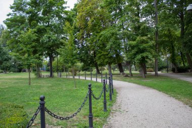 Gölgeli sokakları, kesilmiş çimleri, dekoratif çalıları ve ağaçlarla dolu güzel, bakımlı yeşil bir Avrupa parkı.