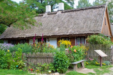 Bir yaz gününde bir sazçatı, veranda, hasır çit, çiçek yatak ile geçen yüzyılın otantik yeniden ev. 20. yüzyılın başlarında Avrupa'nın kırsal ında mimarisi.