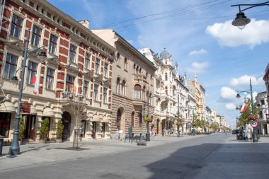 Lodz/ Polonya - 17 Ağustos 2019: Polonya'nın orta kesimindeki Lodz kentinin ana turistik yaya caddesinde bir yaz gününde antik mimari, kafeler, restoranlar ve çiçekler.