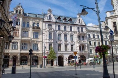 Lodz/ Polonya - 17 Ağustos 2019: Polonya'nın orta kesimindeki Lodz kentinin ana turistik yaya caddesinde bir yaz gününde antik mimari, kafeler, restoranlar ve çiçekler.