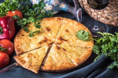 Gri yüzeyde geleneksel gürcü hachapuri ve taze sebzeler